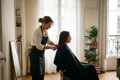 Coiffeuse à domicile réalisant une coupe de cheveux pour une cliente dans un appartement lyonnais
